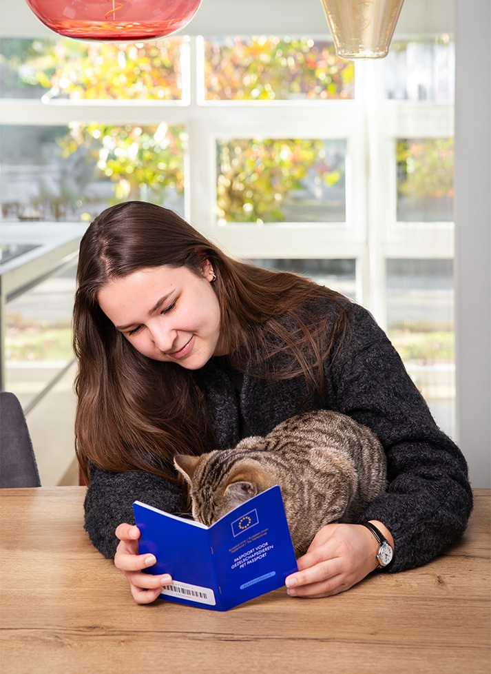 Houder van kat leest dierenpaspoort voor EU reizen